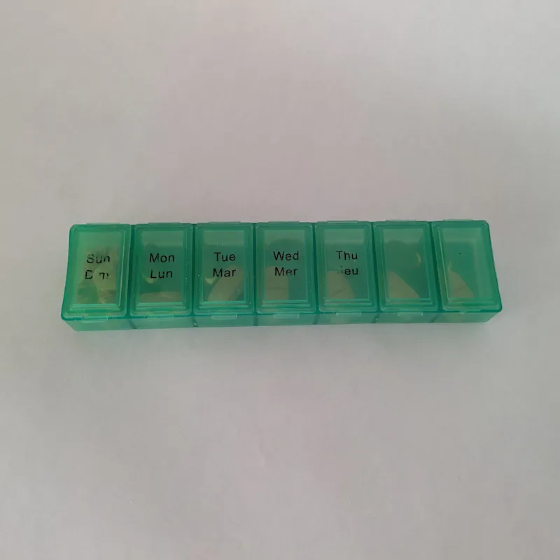 A green translucent 7-day pillbox for organizing weekly dog supplements.
