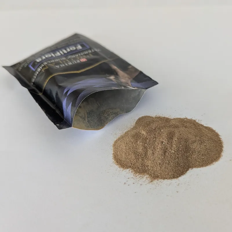 Fine brown FortiFlora probiotic powder poured out of a sachet onto a white surface.