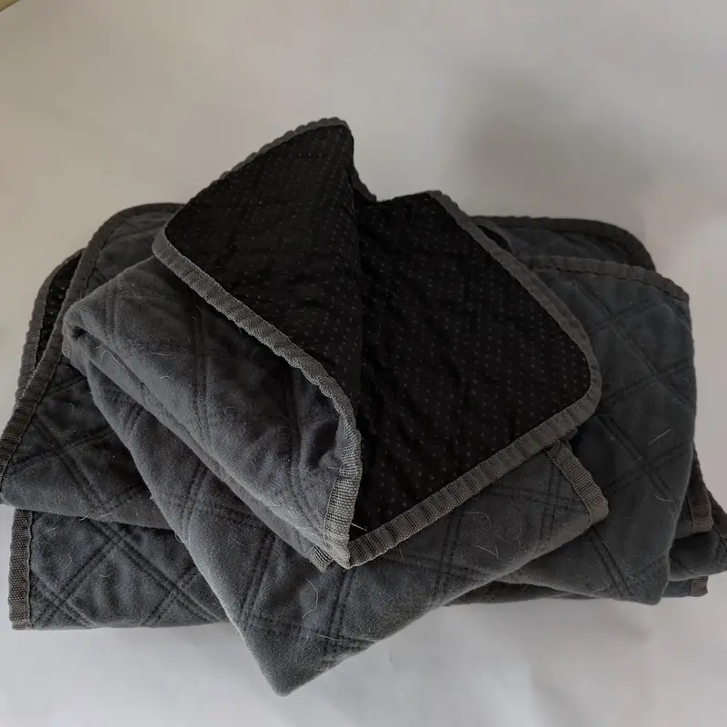 Close-up of a small quilted blue washable pad showing the absorbent texture.