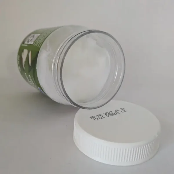 An open jar of solid white virgin coconut oil showing its natural texture.