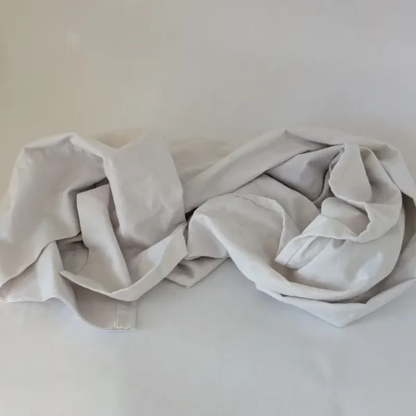 Une taie d'oreiller pour le corps en coton blanc doux pouvant servir de fronde de mobilité pour chien.