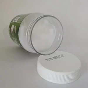 Un pot ouvert d'huile de noix de coco vierge blanche et solide montrant sa texture naturelle.