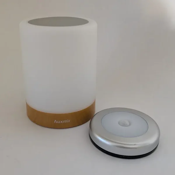 Veilleuse globe tactile blanche portable avec base en bois et une lampe à capteur de mouvement circulaire séparée.