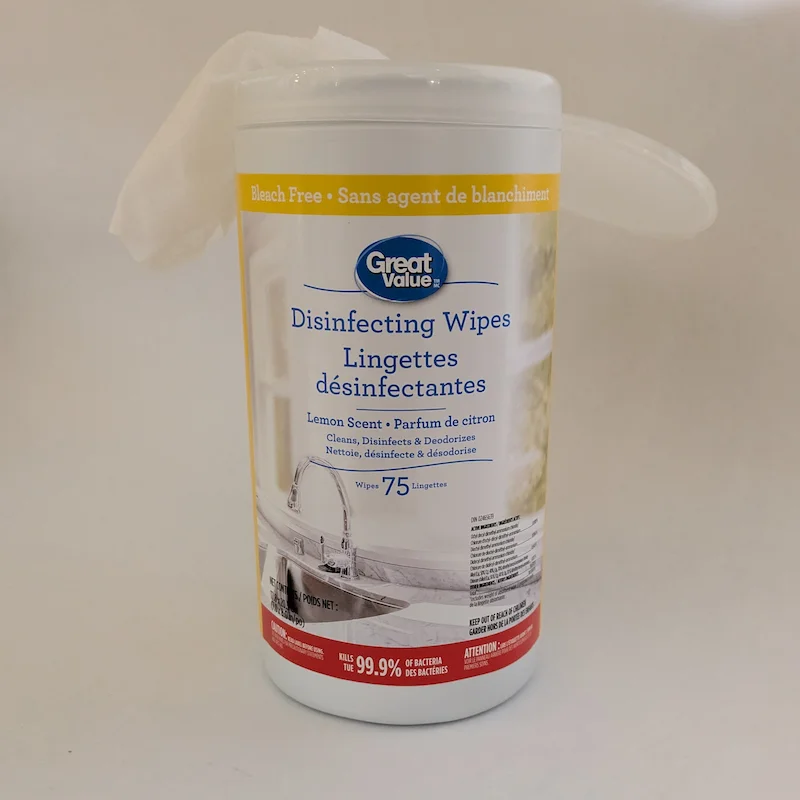 Une lingette désinfectante tirée à travers le couvercle du distributeur pour un accès facile.