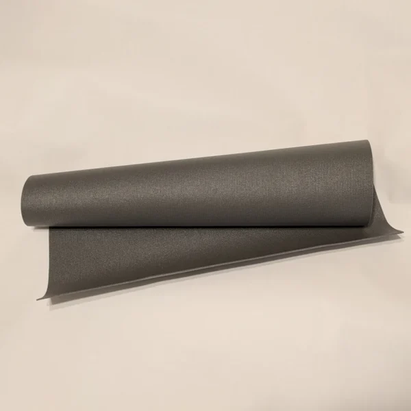 A roll of dark grey non-slip shelf liner used as a low-profile traction mat.