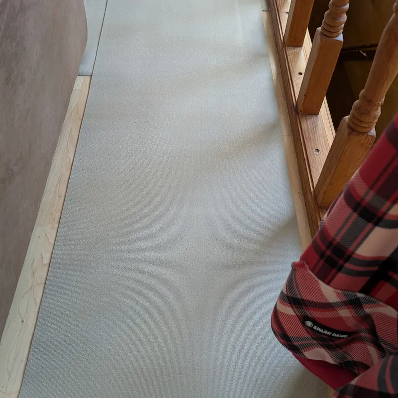 Beige shelf liner laid out as a mobility pathway along a hallway for a senior dog.