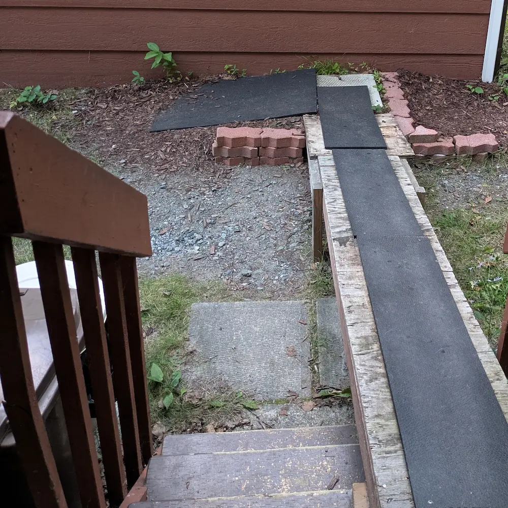 A view of the custom-built ramp at the back door, designed with a gentle incline to replace stairs and provide safe, easy access for a senior dog.