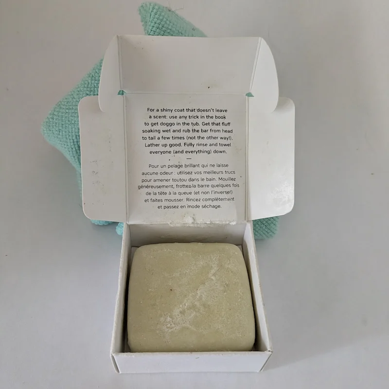 An eco-friendly solid shampoo bar in its original cardboard packaging.